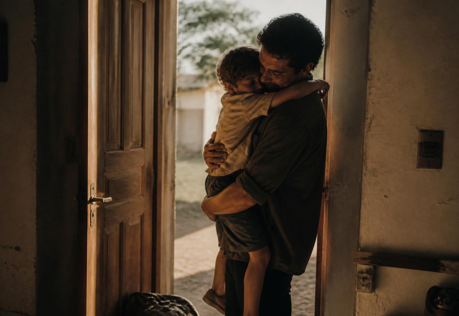 Trabalhador reencontrando o filho ao chegar em casa após um dia de trabalho